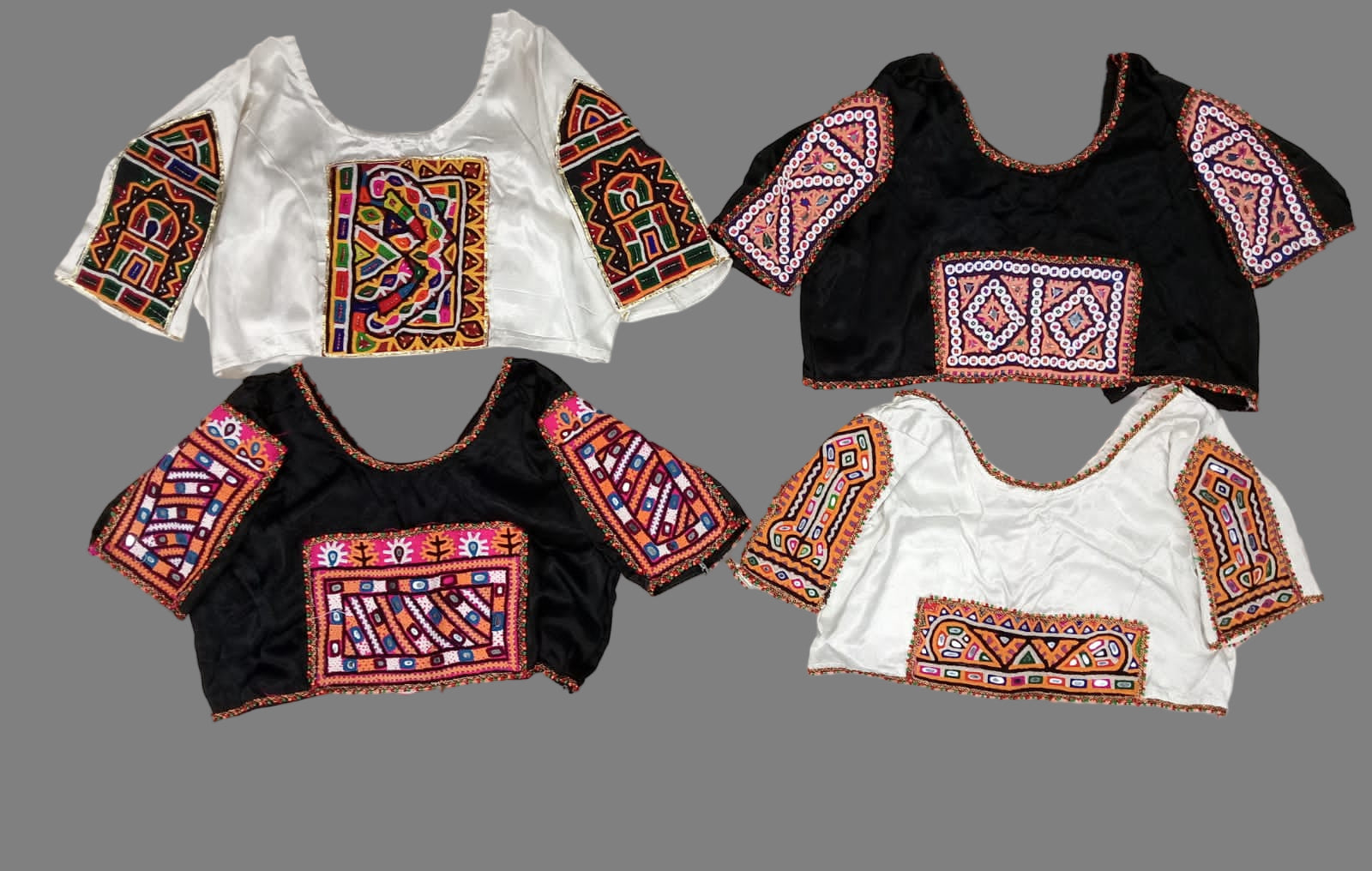 Blouses with colorful embroidery on a light gray background.